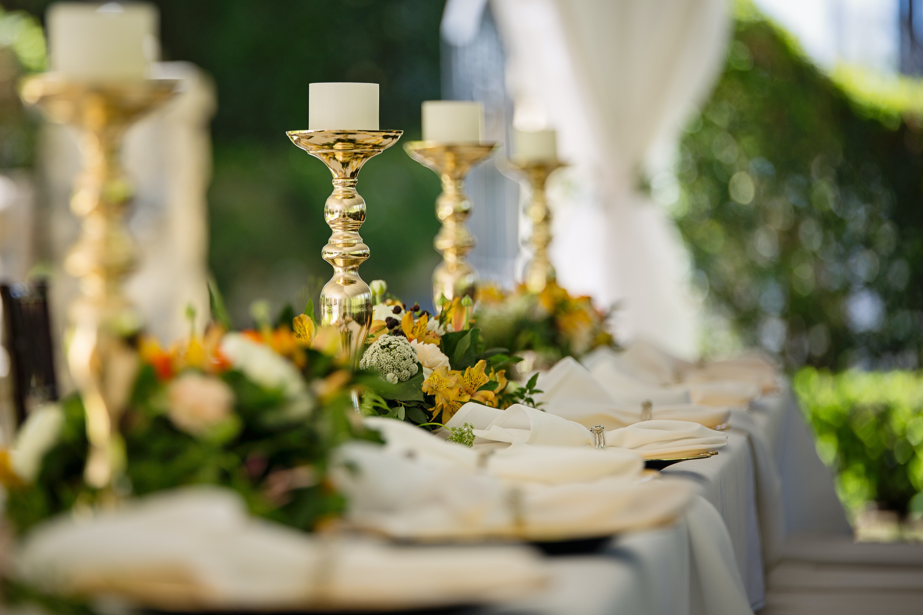Outdoor gold candlestick table setting with florals